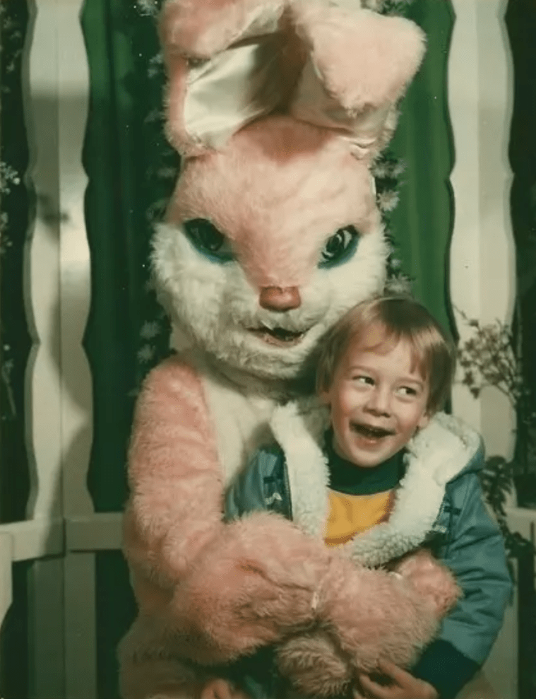 Pink bunny with boy in clutches